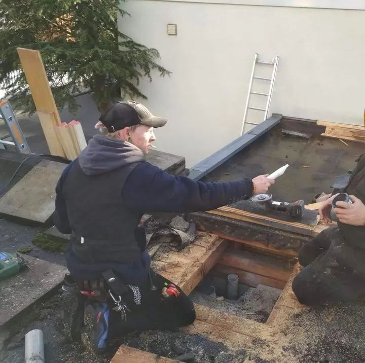 Arbeiten an einer Flachdach-Unterkonstruktion aus Holz